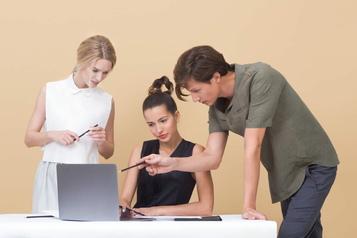 man teaching woman while pointing on gray laptop.jpg