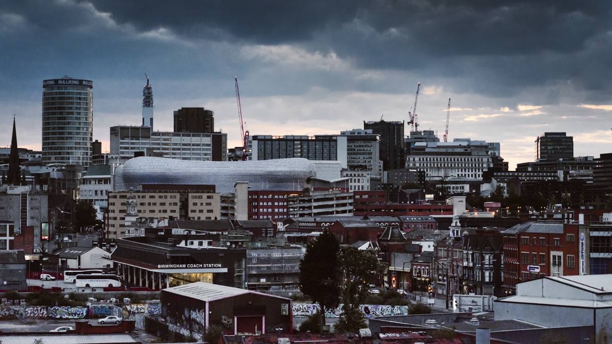 concrete building and houses under gray sky.jpg