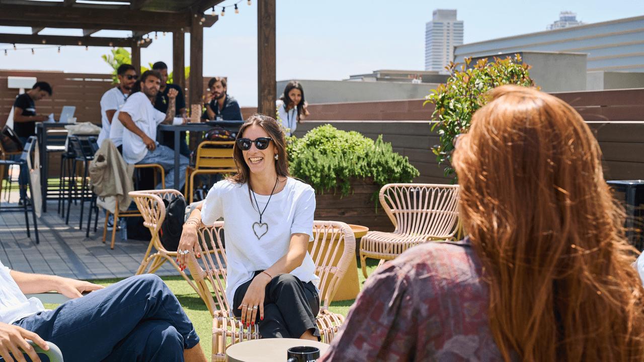 four women holding drinks while laughing together during daytime