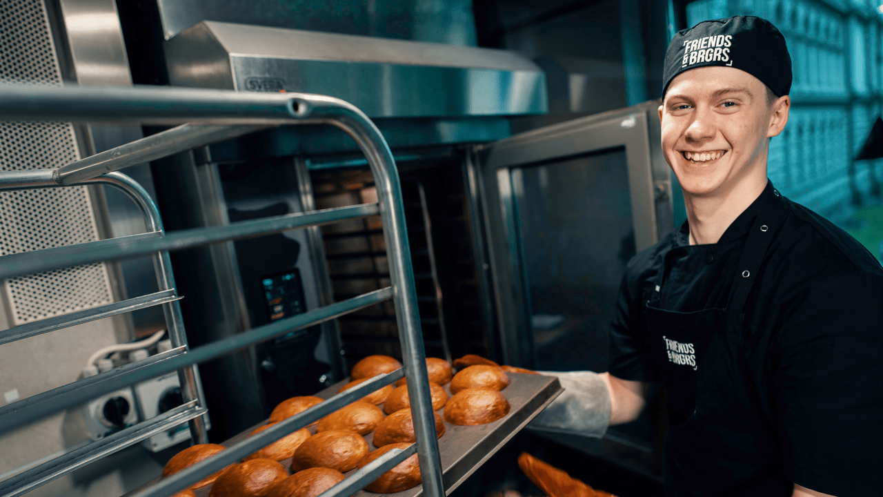 Työntekijä leipoo sämpylätaikinaa