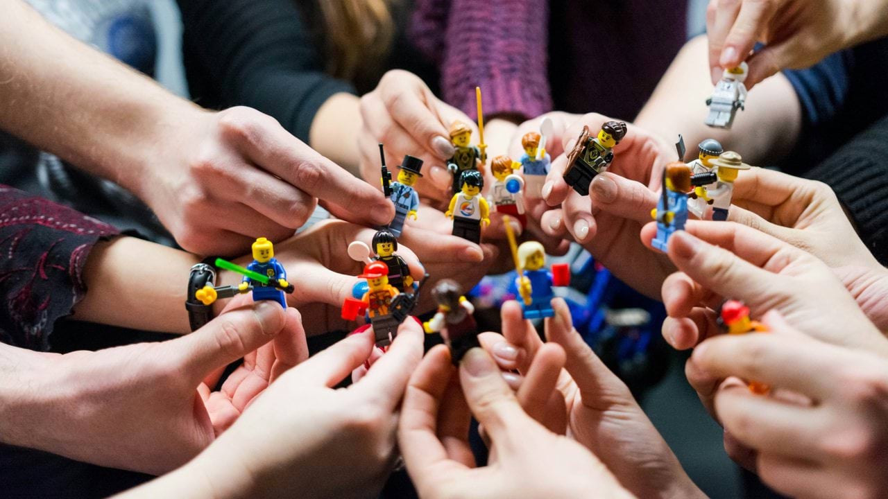 people holding miniature figures