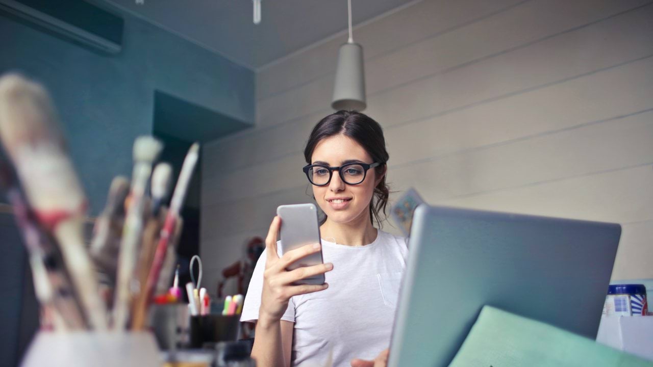 woman in white shirt using smartphone