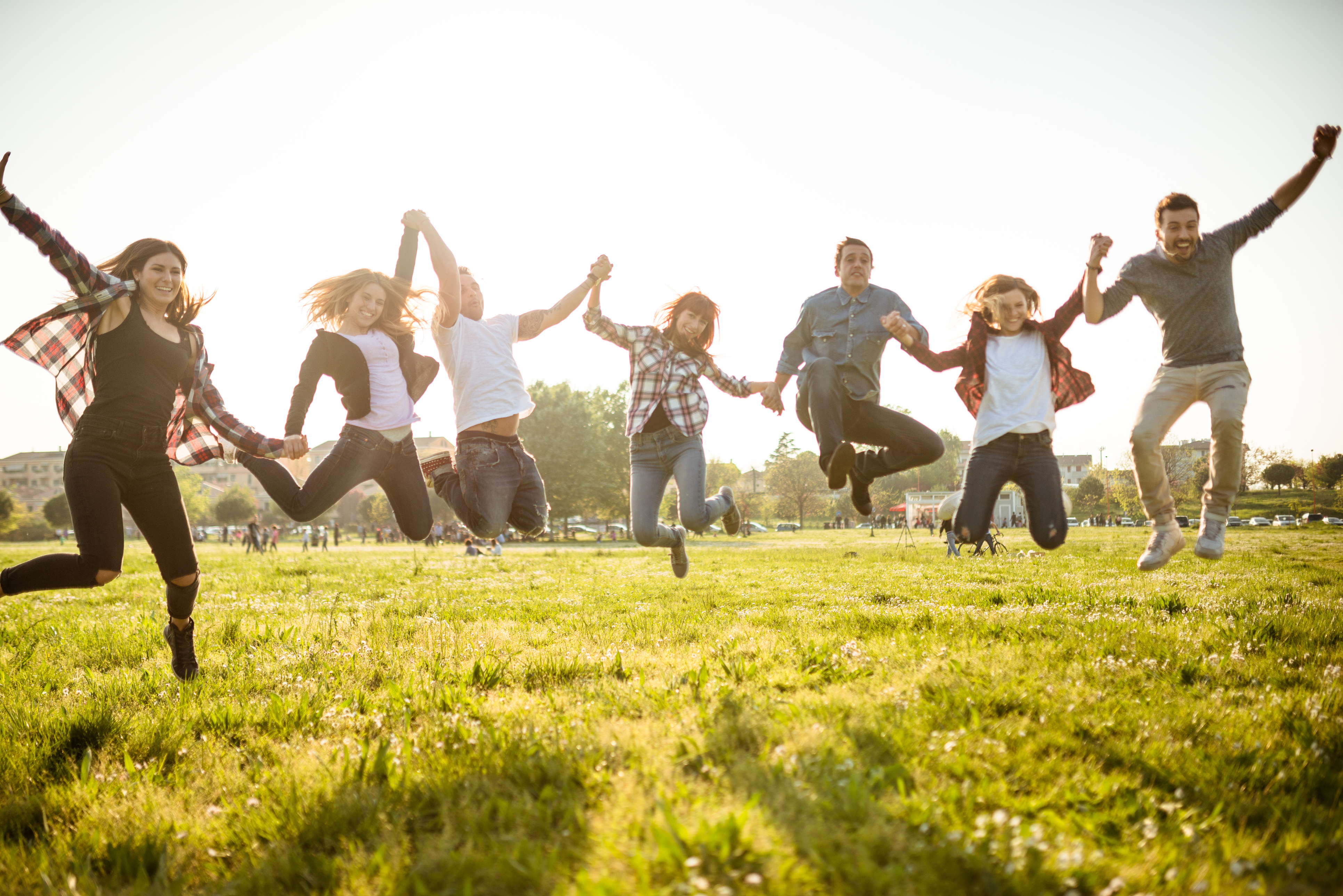 Sju personer hoppar på en äng
