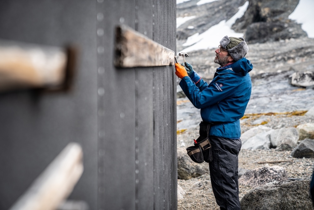 Carpenter fixing outside of base hut