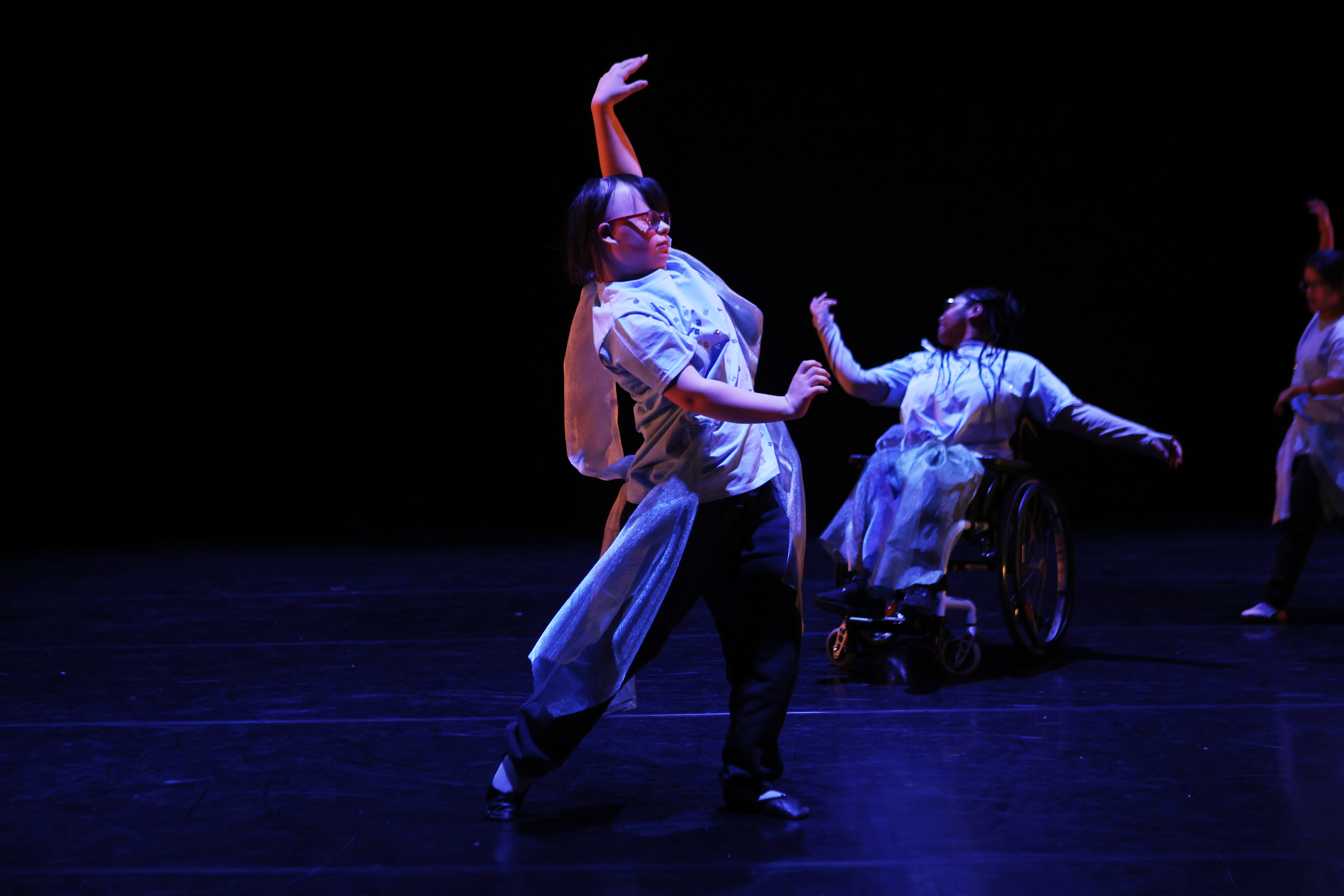 Image of dancers on a dark stage.