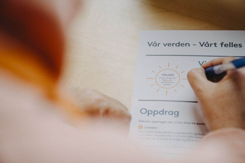 Hånd skriver på Stendi-dokument med teksten ‘Vår verden – vårt felles ansvar