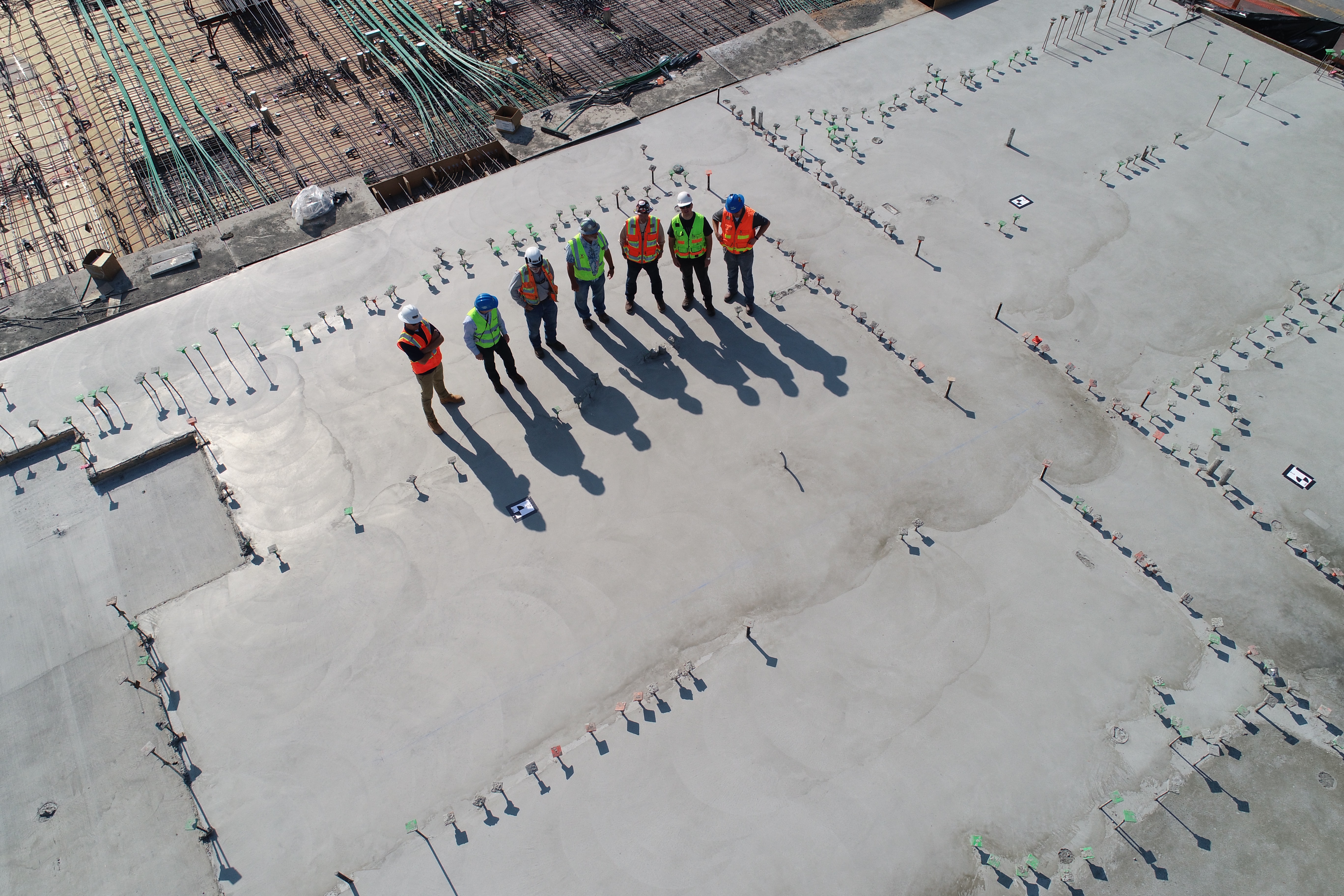 seven construction workers standing on white field