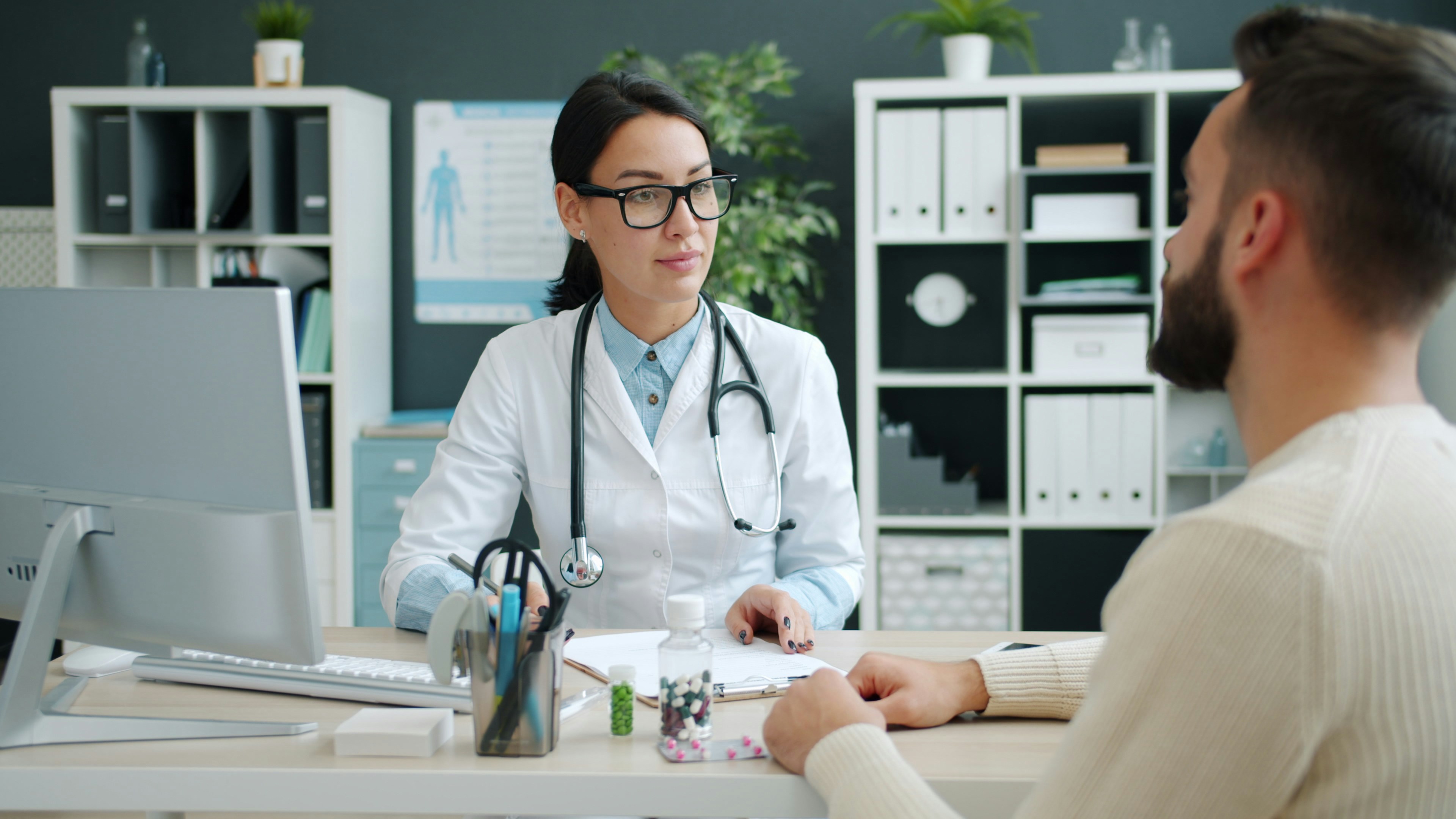 Doctor consults with patient in medical office.