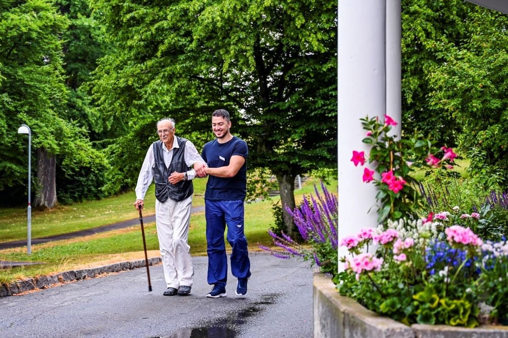 En kund är ute och går med stöd av en medarbetare
