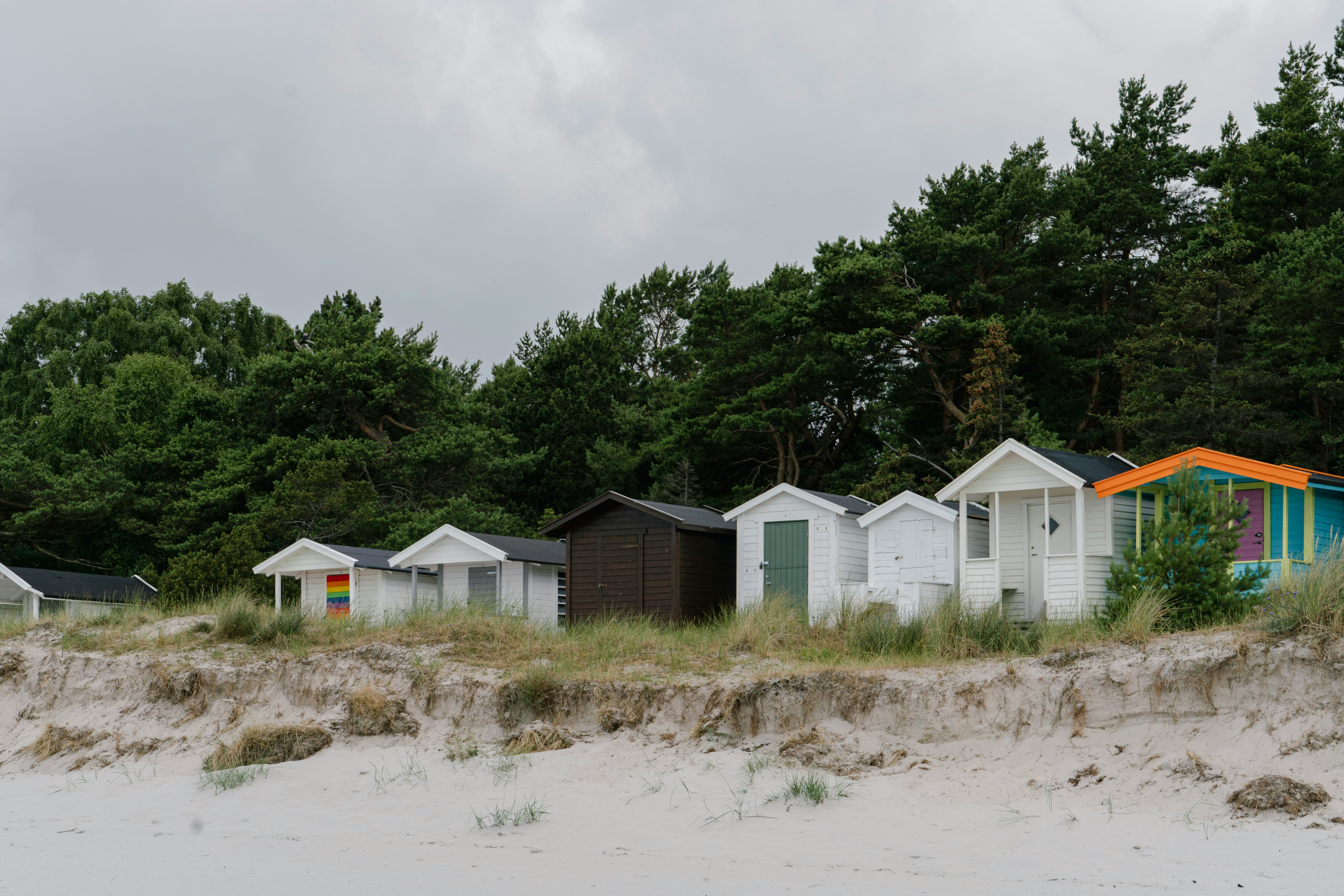 A row of beach huts sitting on top of a sandy beach