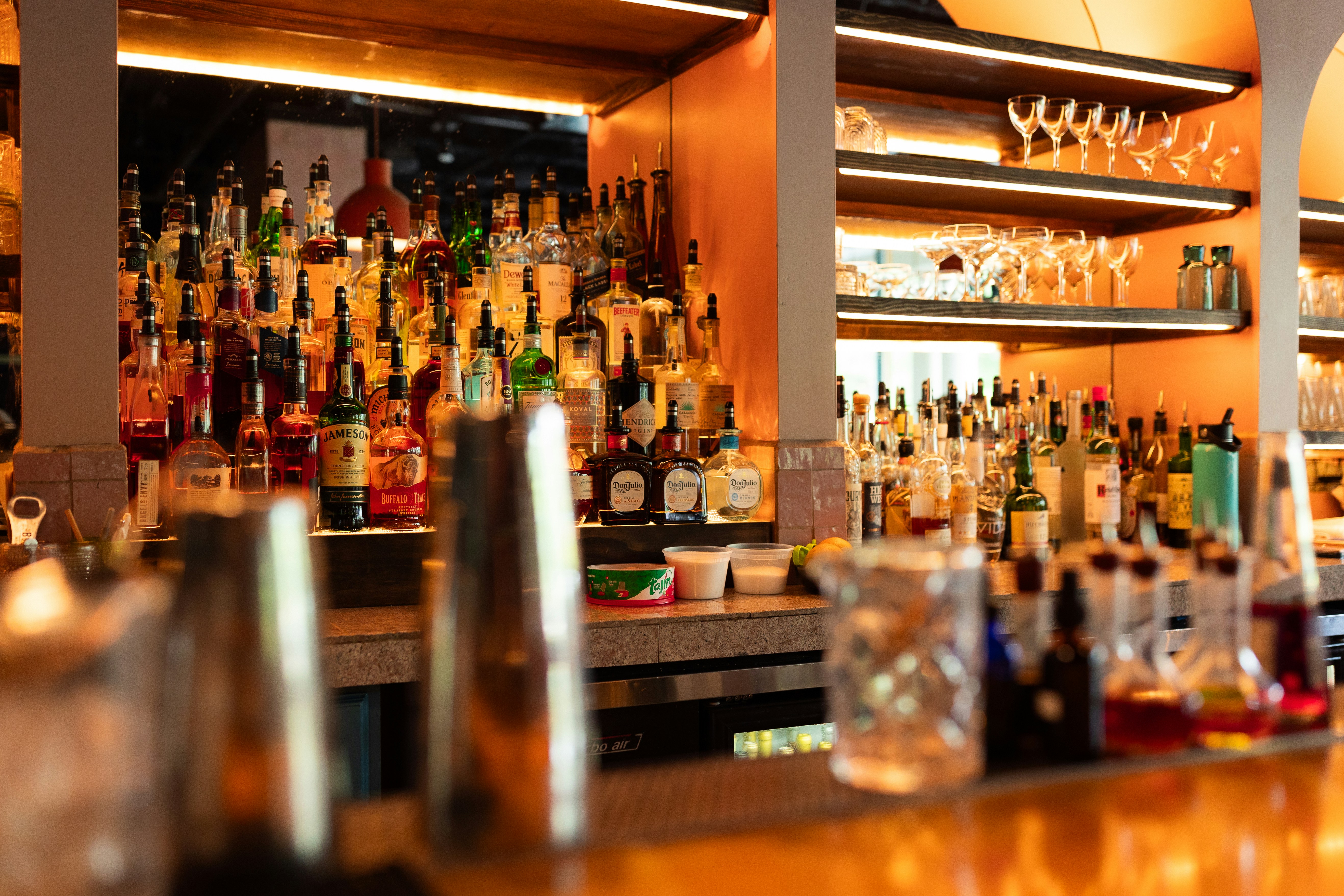 A bar filled with lots of bottles and glasses