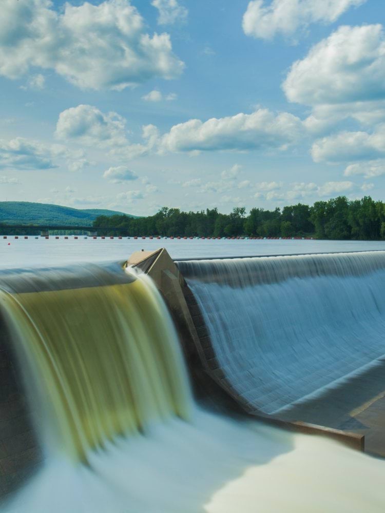 water dam under white and blue skies