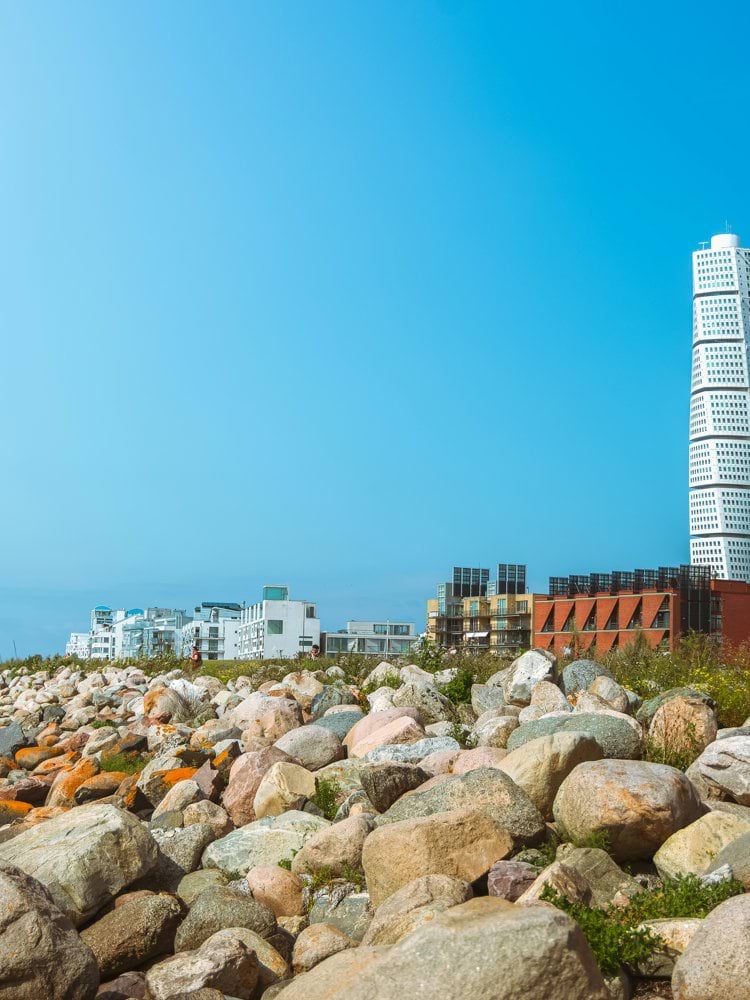 A seaside cityscape features a striking modern tower