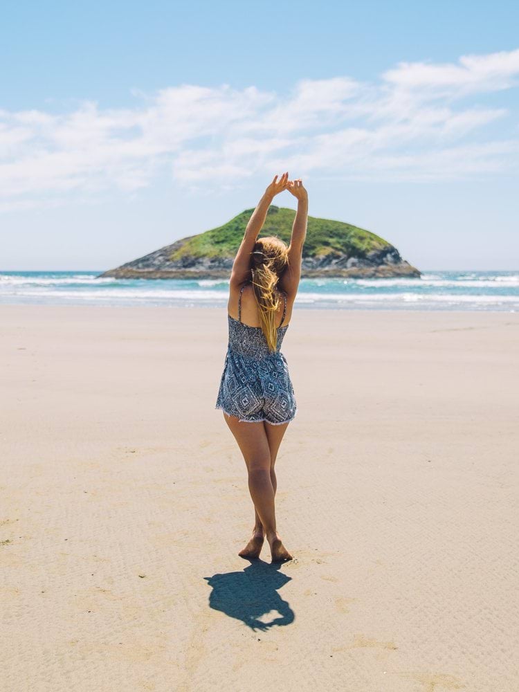 woman on seashore near island under blue sky