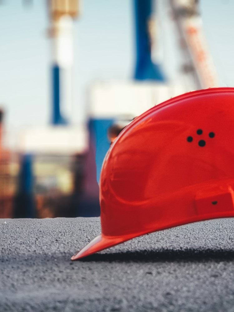red hard hat on pavement\