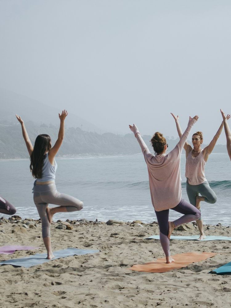 five woman standing on seashore