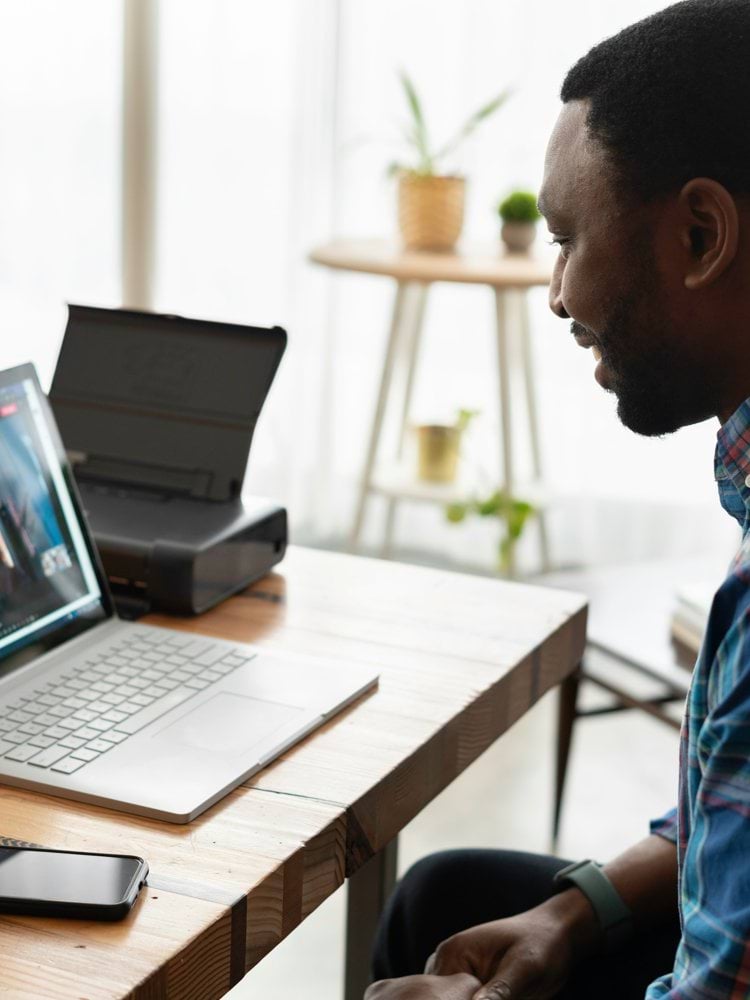 man in blue and white plaid dress shirt using macbook pro
