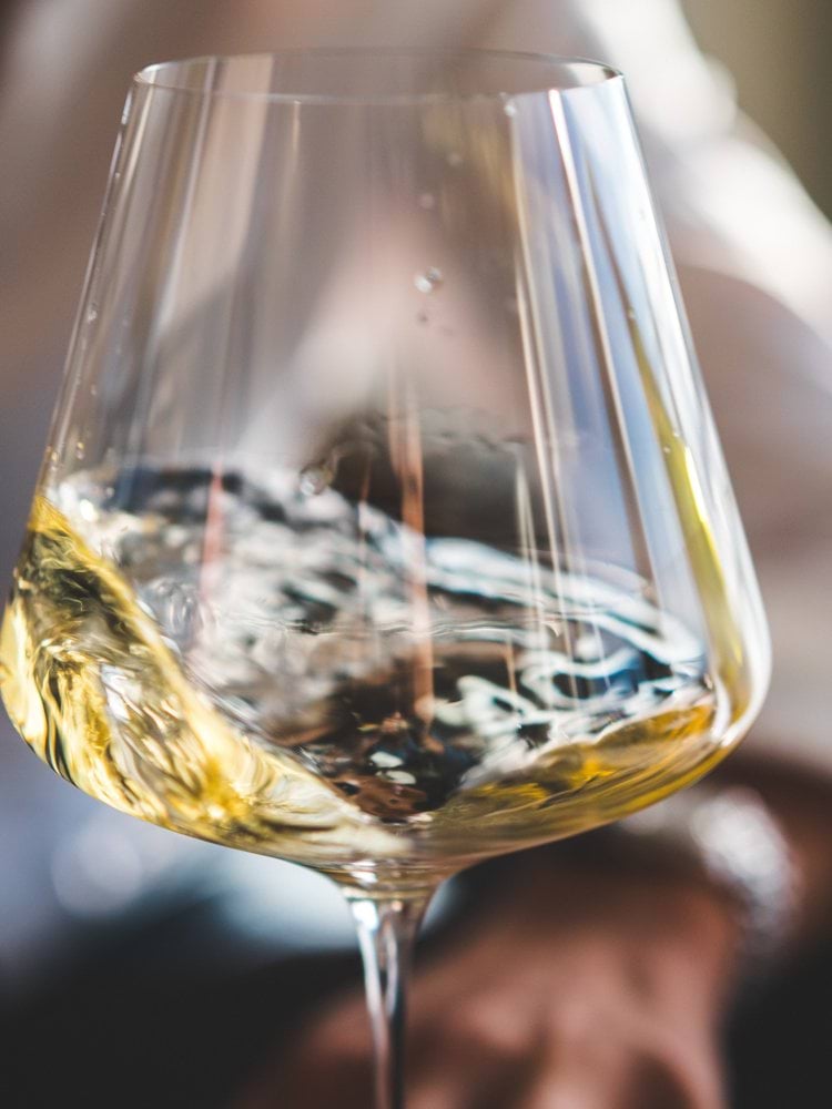 clear wine glass with yellow liquid