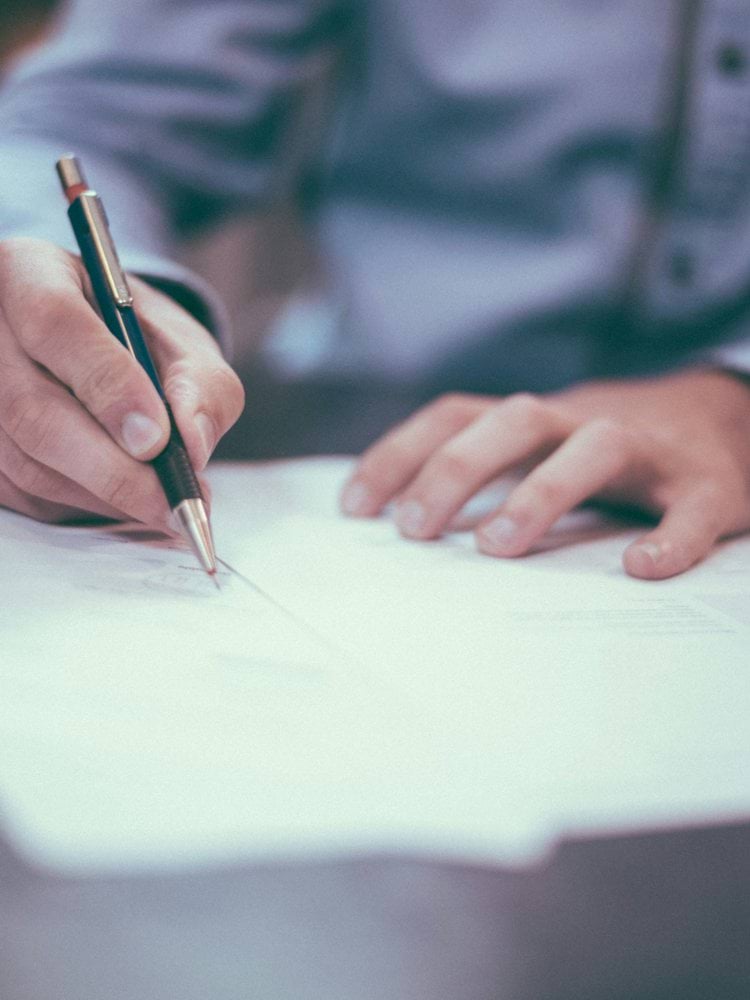 man writing on paper