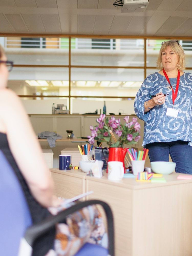 a woman explaining something to a group of people