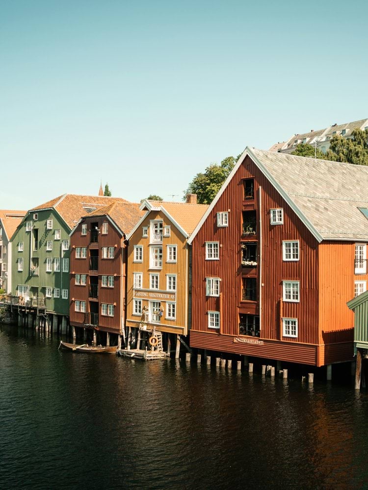 green and brown wooden houses beside river during daytime
