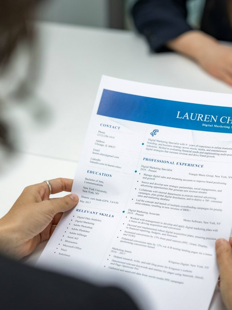 a woman is reading a resume at a table