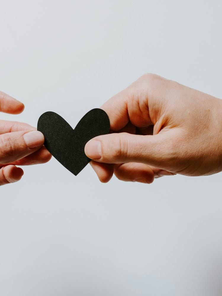 two person holding papercut heart