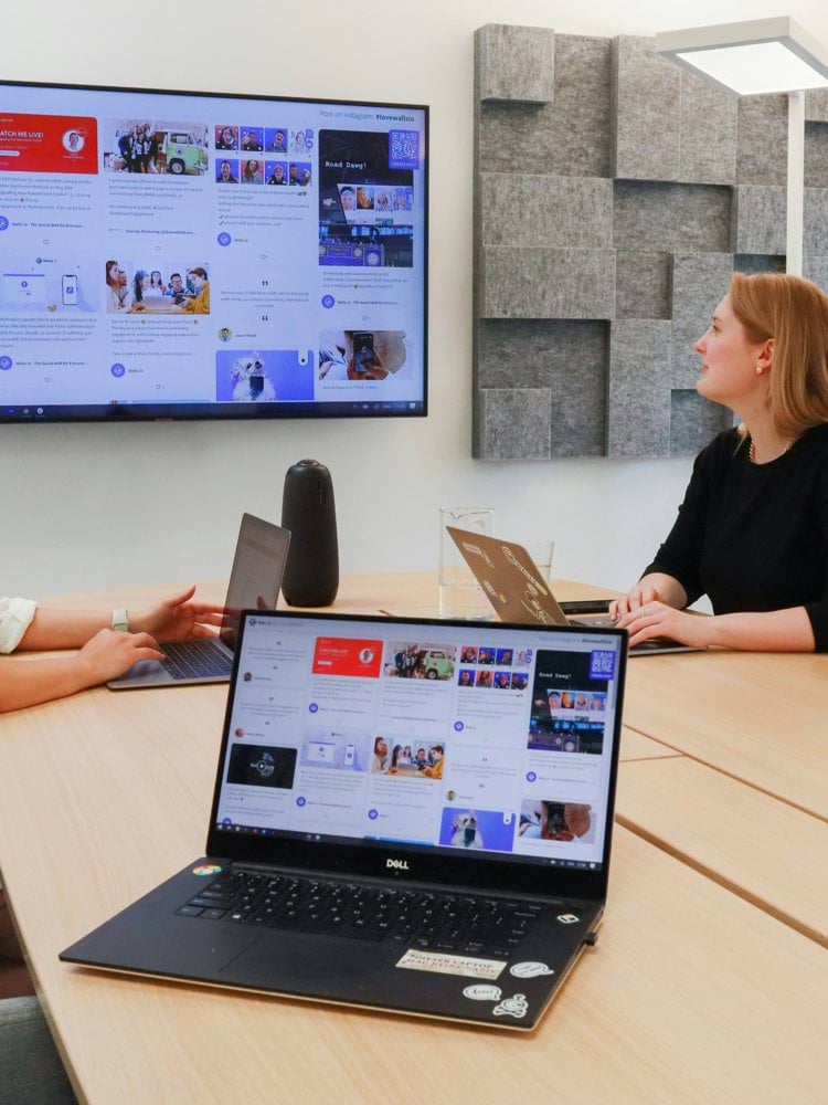two women sitting at a table with a laptop