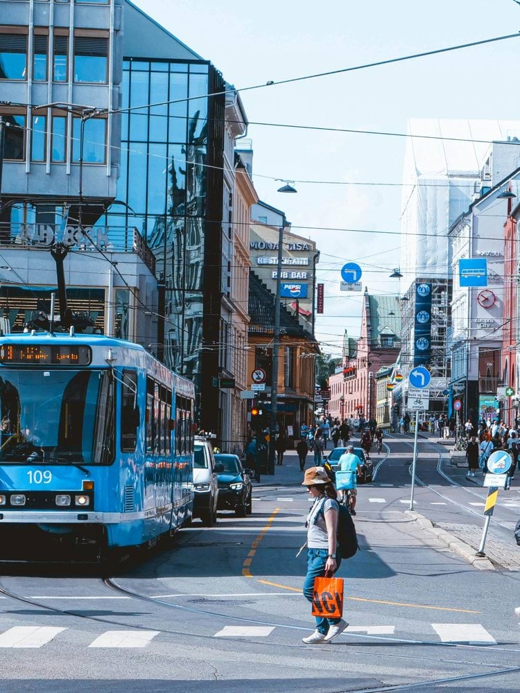 a blue bus driving down a street next to tall buildings