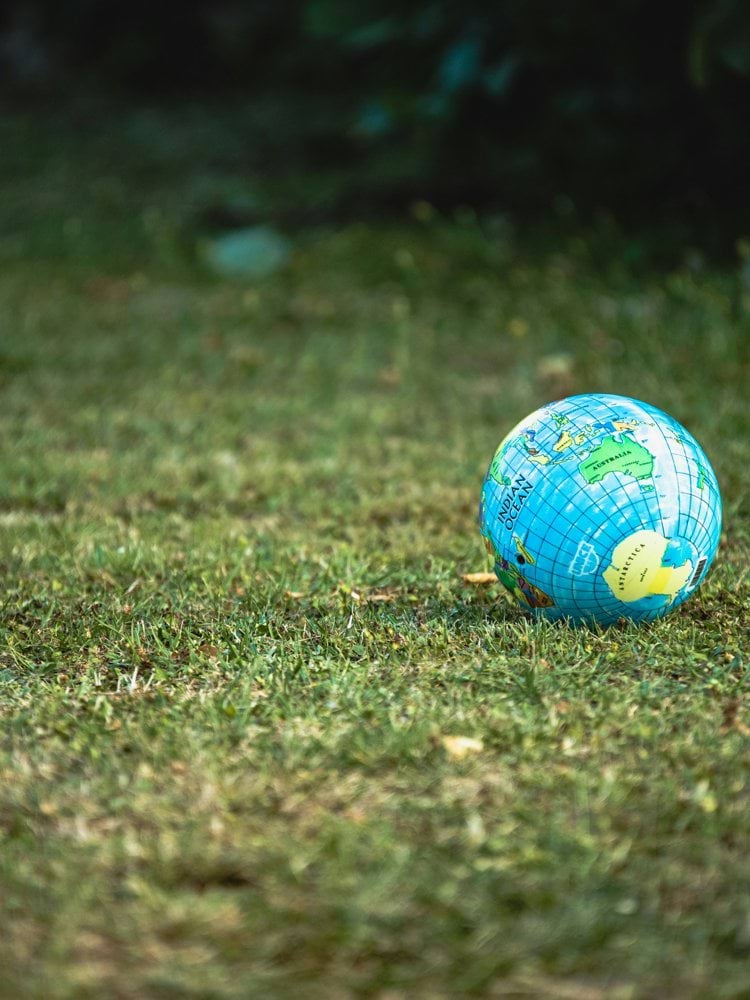 blue and white desk globe on green grass field during daytime