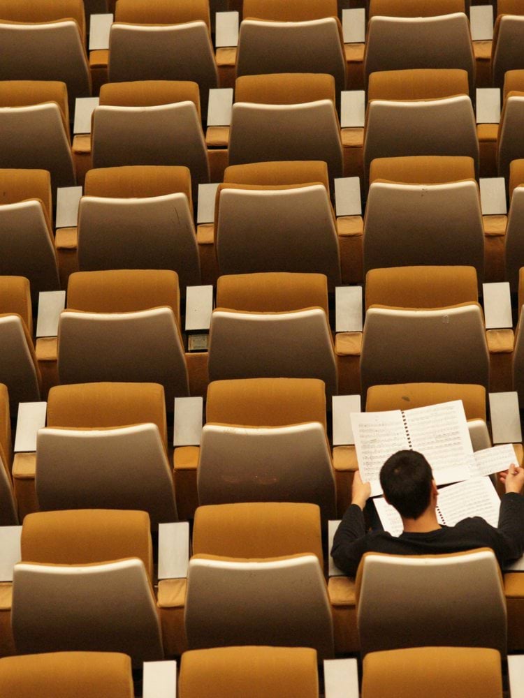 person reading in empty lecture hall