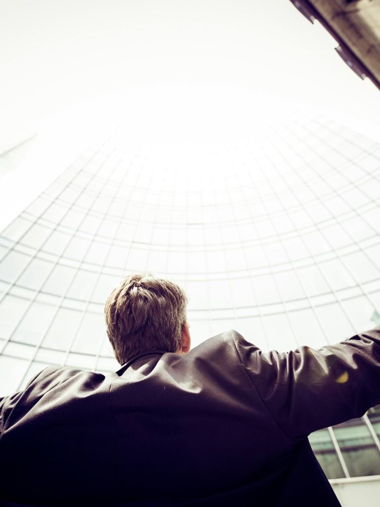 low-angle photography of man in the middle of buidligns