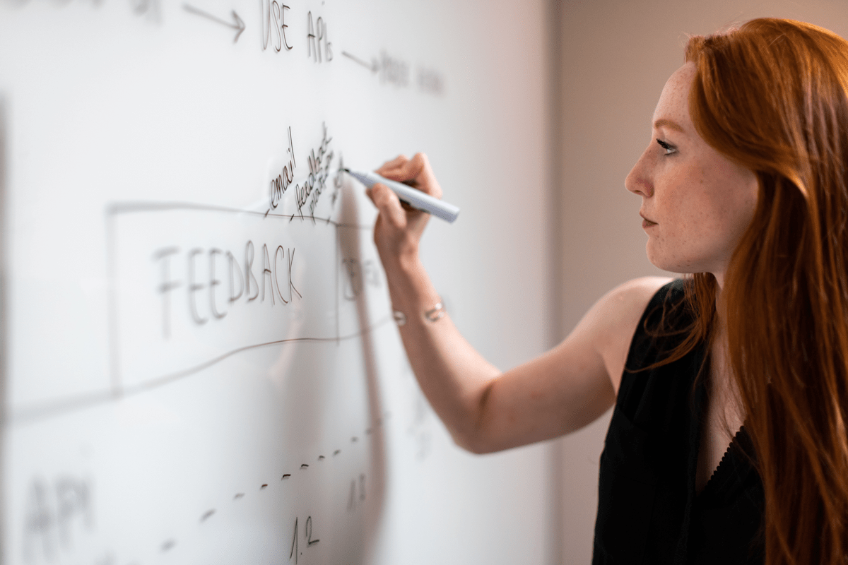 Woman writing on white board