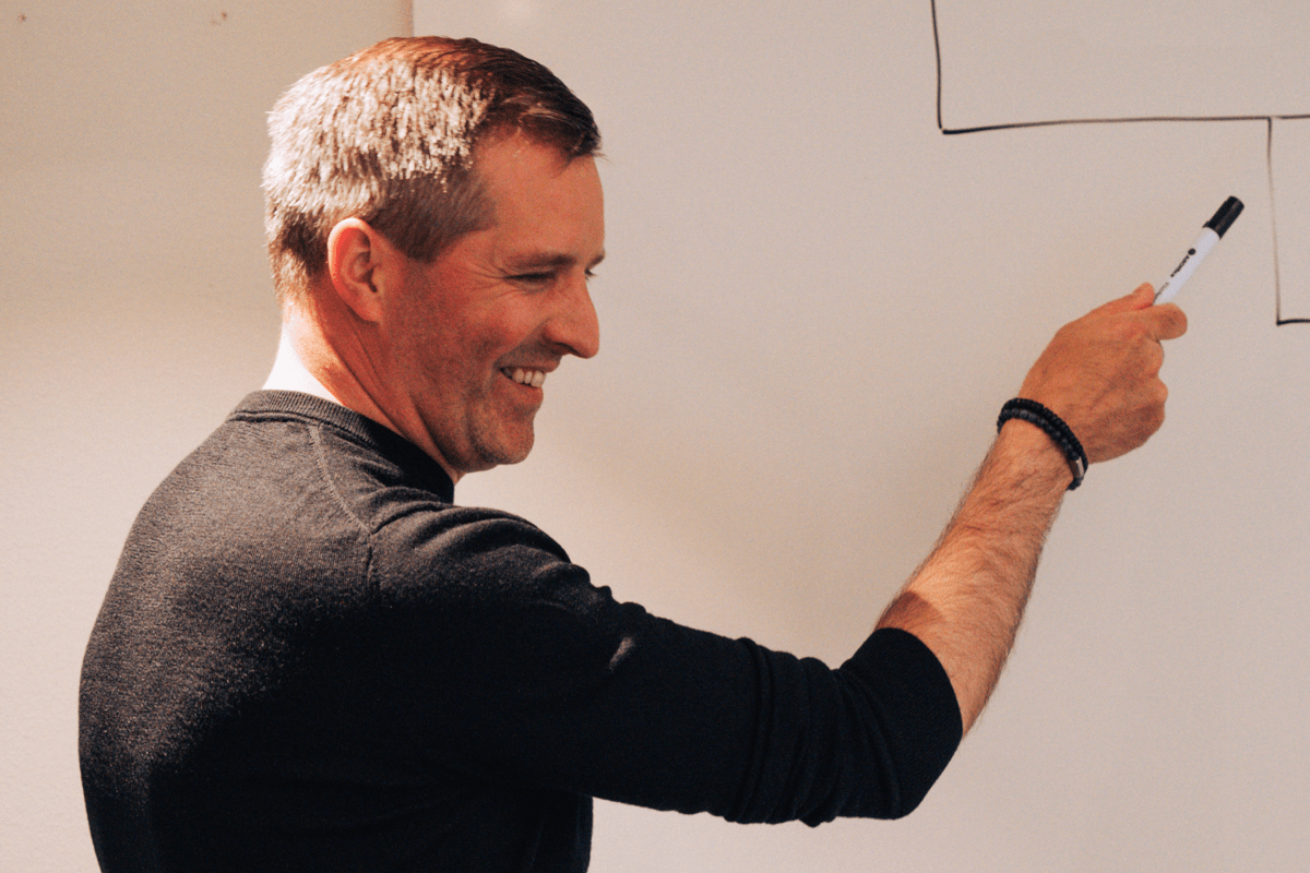 Person perar med en penna på en whiteboardtavla