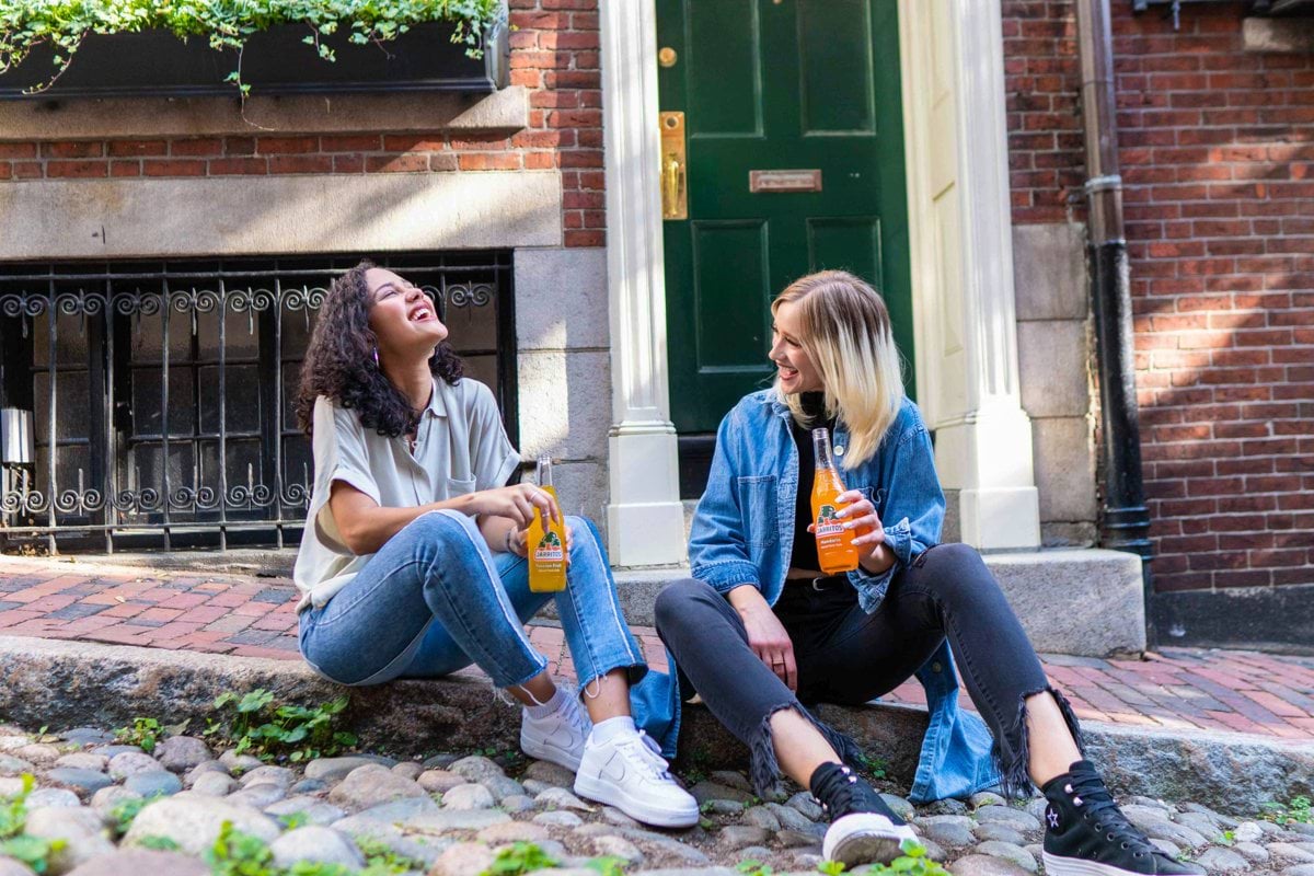 2 women sitting on green grass lawn during daytime