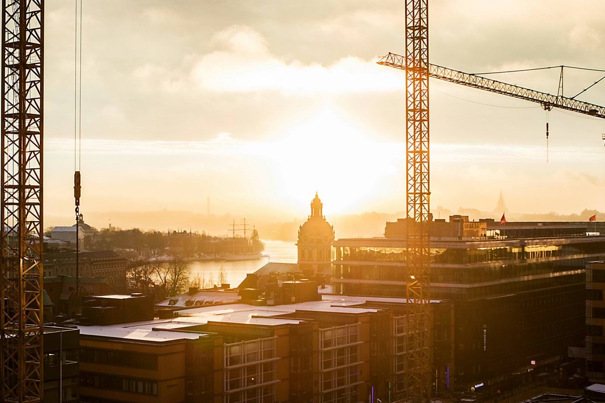 tower crane near building under cloudy sky at daytime