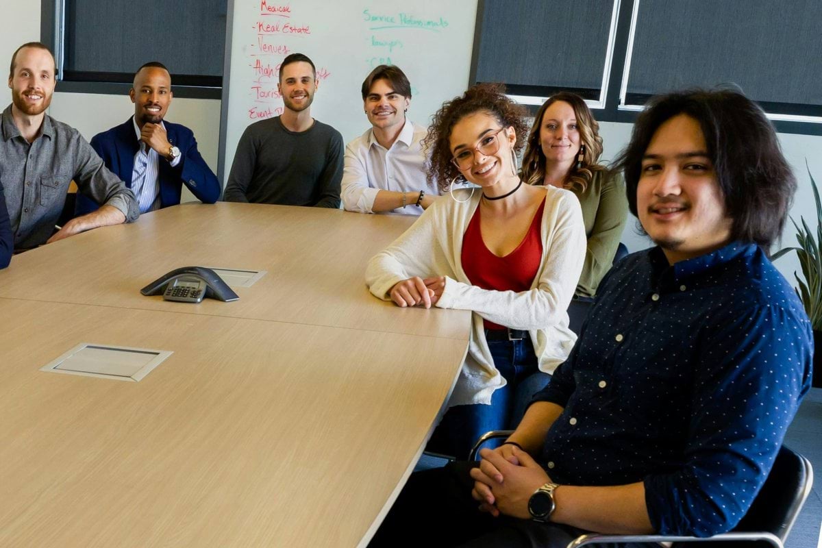 group of people sitting on chair in front of brown wooden table