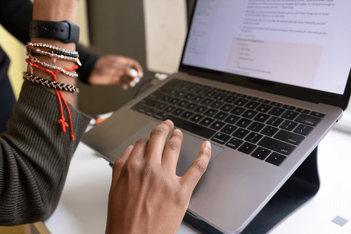A pair of hands working at a MacBook