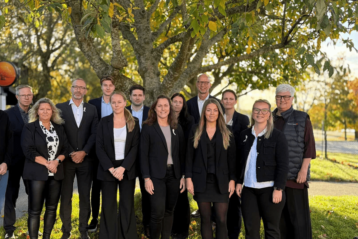 En grupp människor står framför ett träd