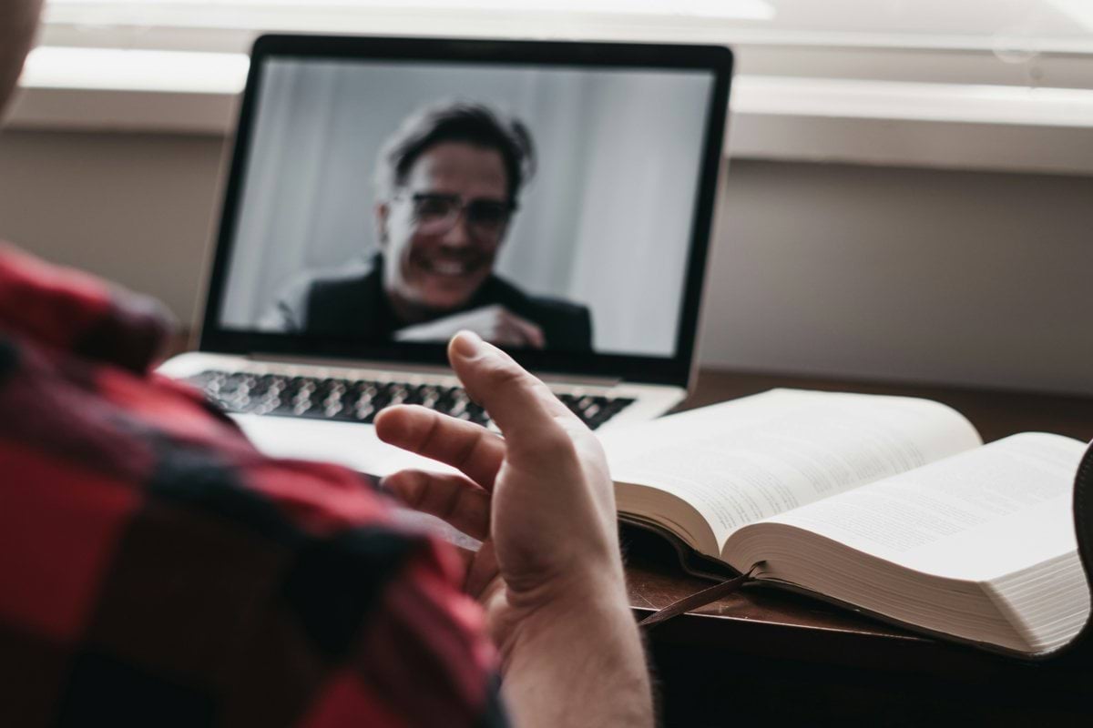 person in red and black plaid long sleeve shirt using black laptop computer