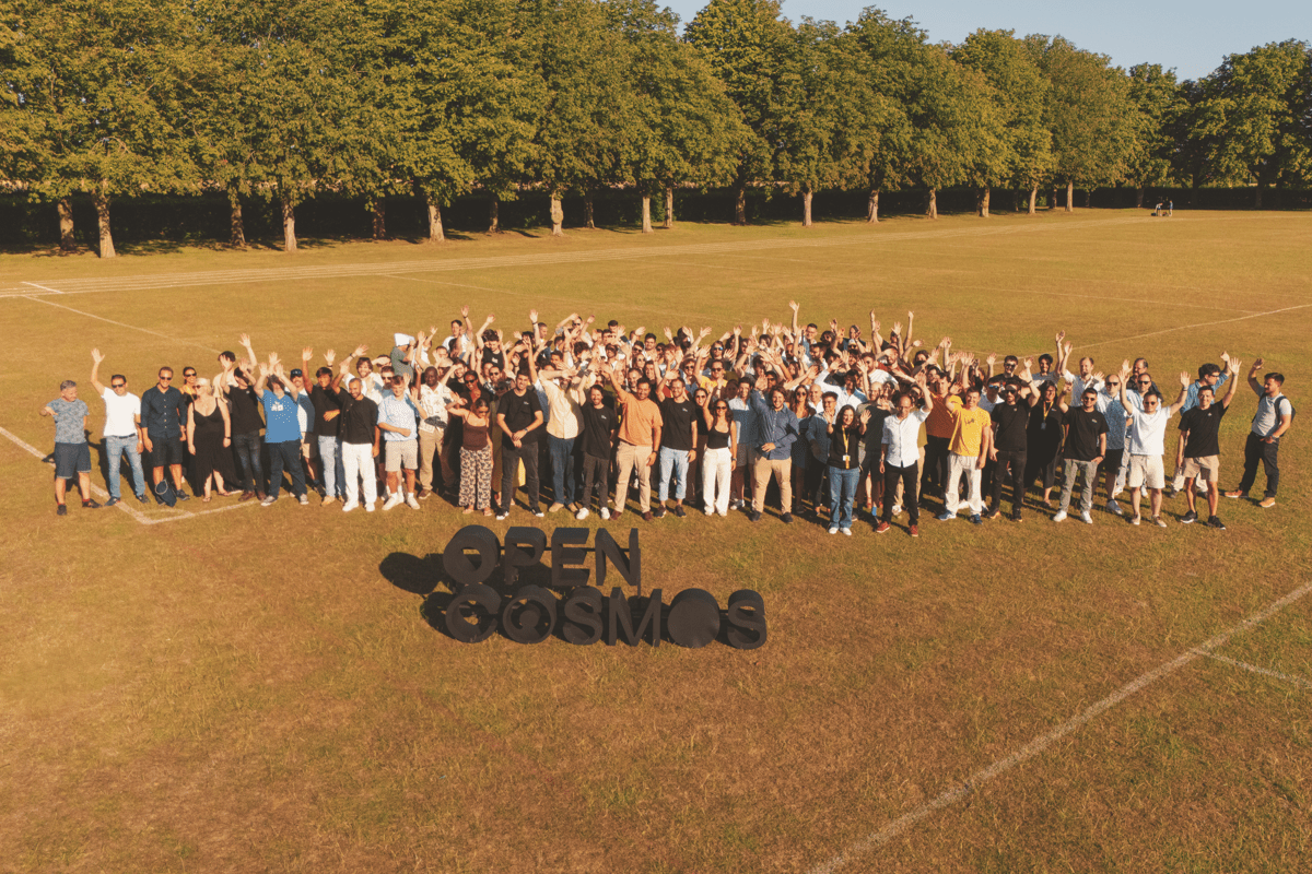 Group of people stand behind Open Cosmos Logo