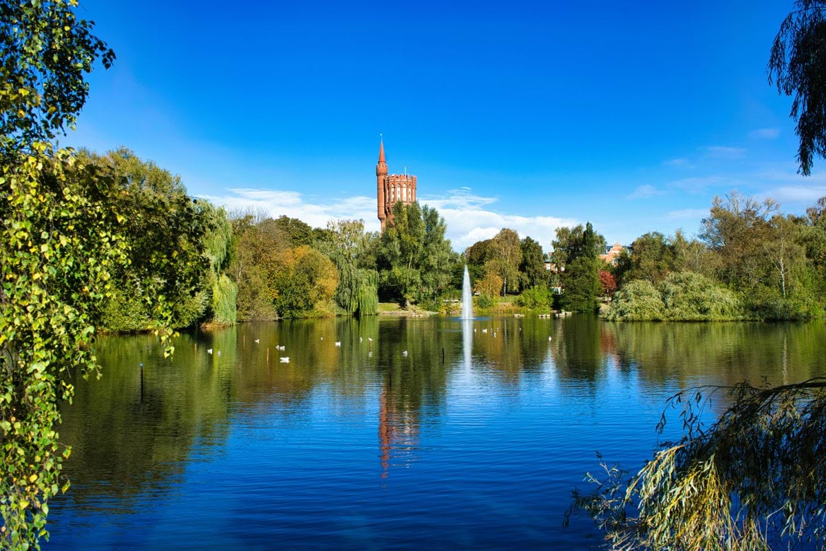 A lake with a clock tower in the background