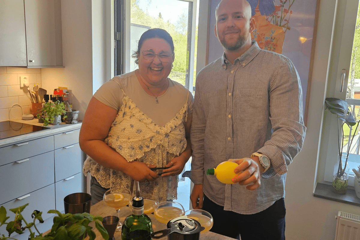 Two people smiling, one holding lemon juice