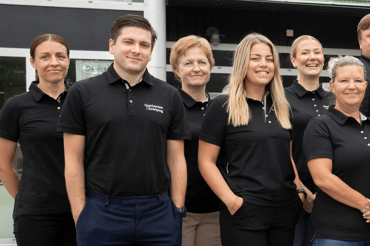 6 personer iklädda svarta pikètröjor med Sparbanken i Eköpings logotyp på