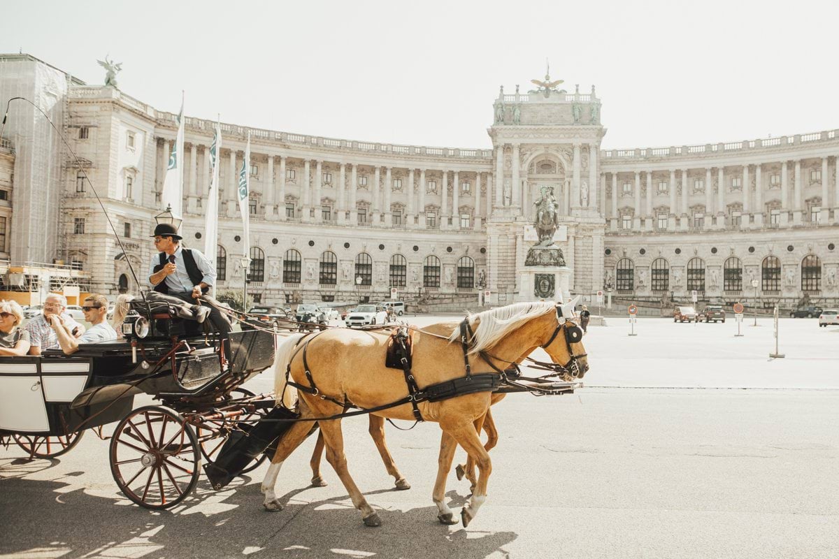 man riding horse carriage on road during daytime