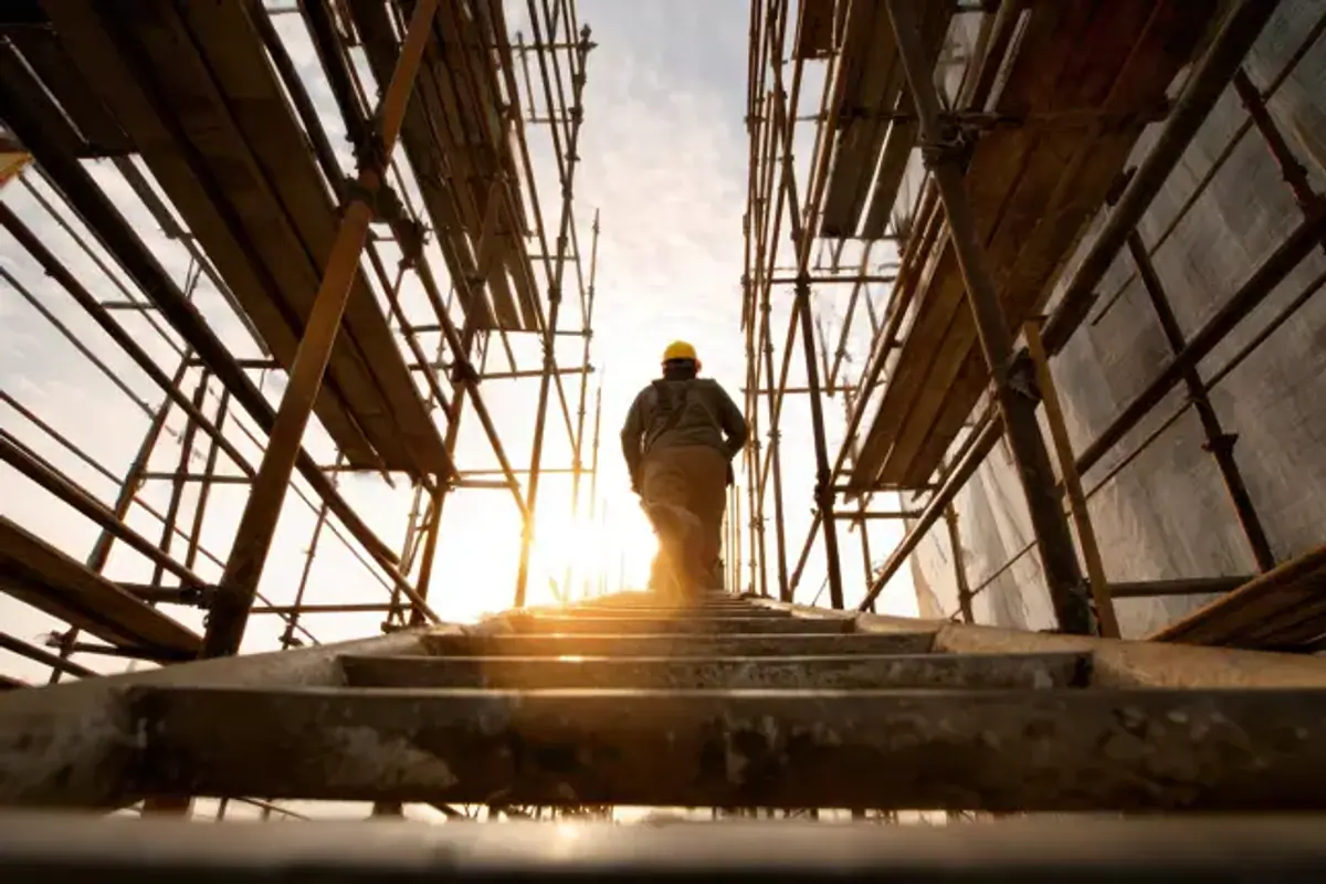 Man walking up construction stairs