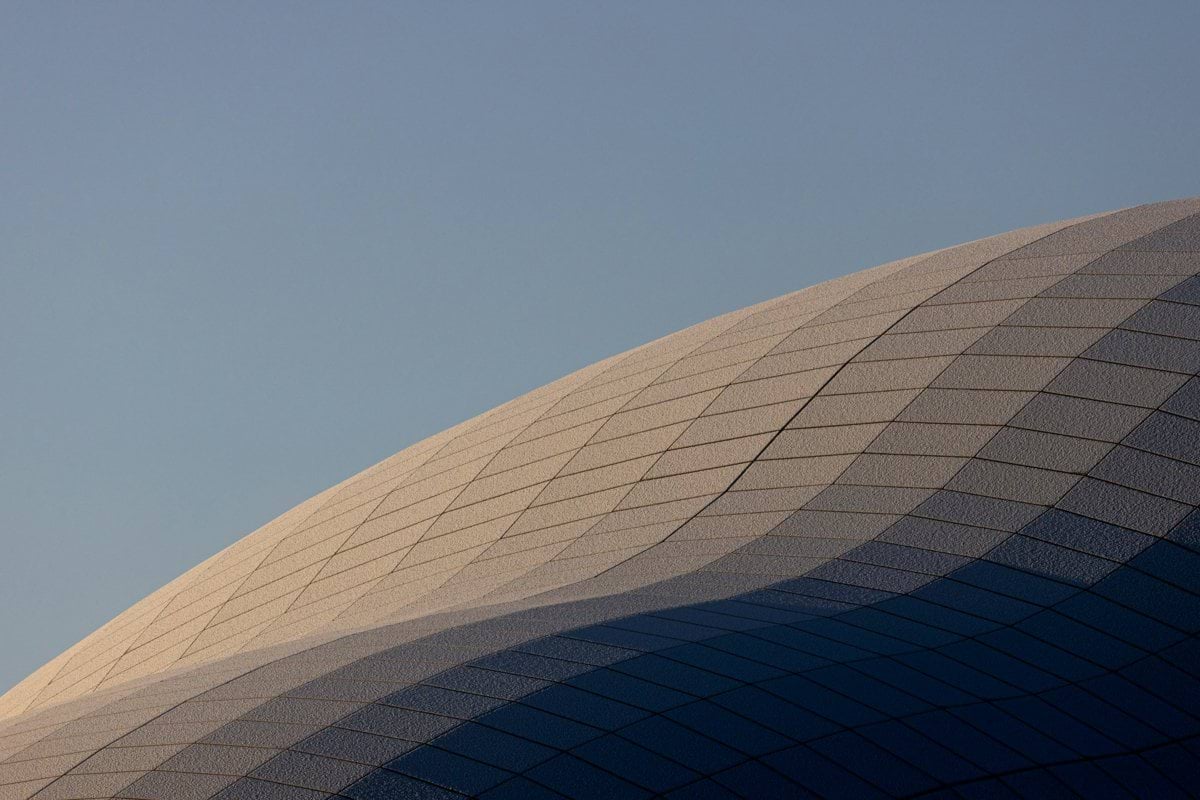 a large building with a plane flying in the sky
