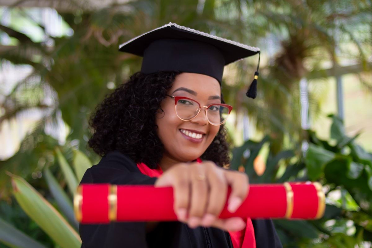 smiling woman wearing academic dress and black academic hat