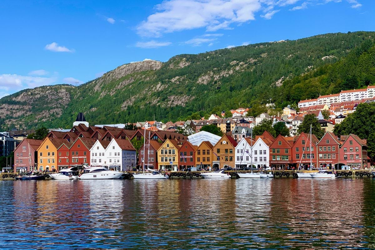 houses near body of water under blue sky during daytime