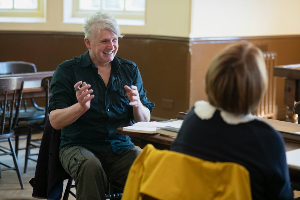 a man sitting at a table talking to a woman